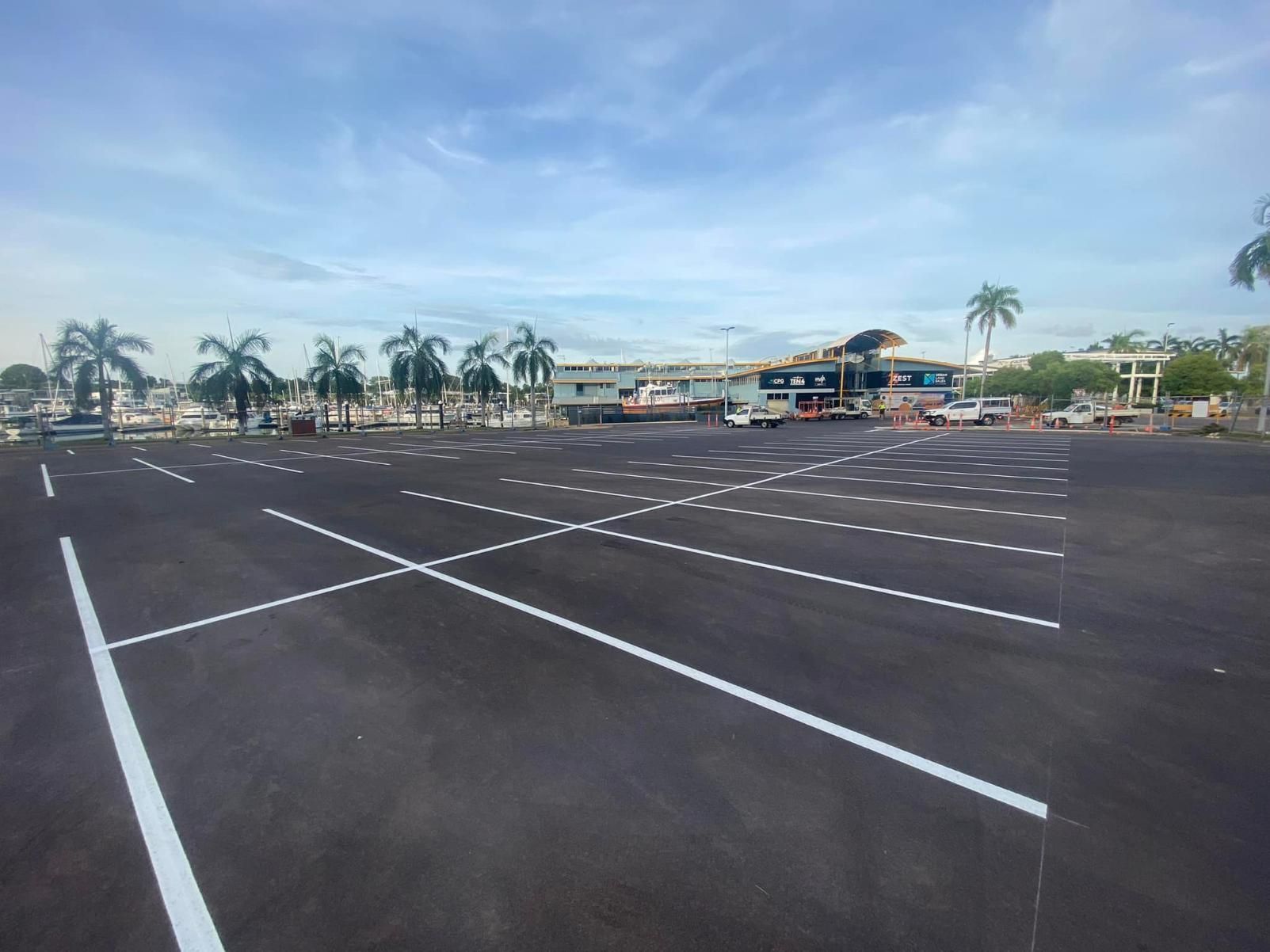 A Parking Lot with White Lines and Palm Trees in The Background — Top End Line Markers Pty Ltd in Jabiru, NT