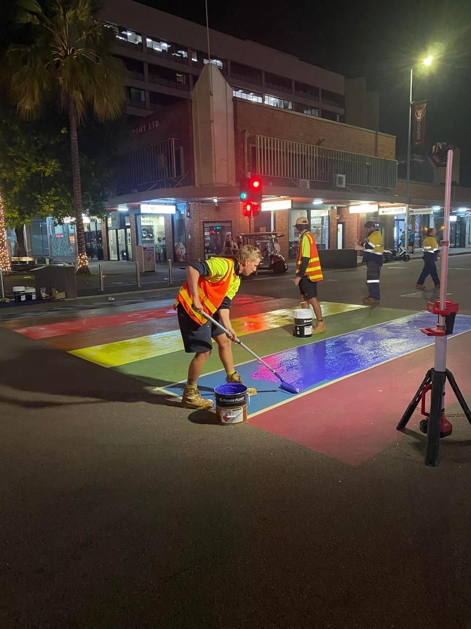 A Group of People Are Painting a Rainbow Crosswalk at Night — Top End Line Markers Pty Ltd in Katherine, NT