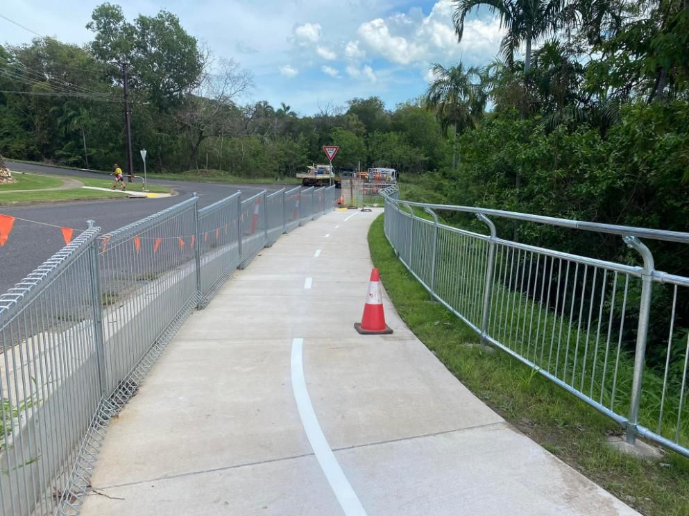 A Concrete Walkway with A Metal Fence and Cones on The Side of It — Top End Line Markers Pty Ltd in Katherine, NT