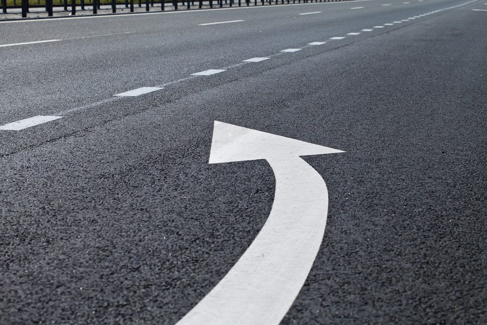 A White Arrow Is Painted on The Side of A Road — Top End Line Markers Pty Ltd in Katherine, NT