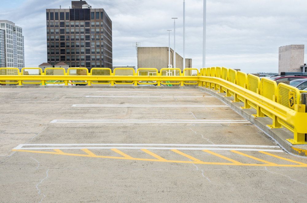 An Empty Parking Garage with Yellow Barriers and A City in The Background — Top End Line Markers Pty Ltd in Jabiru, NT