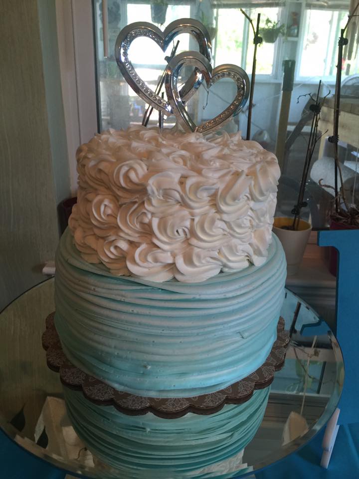 A cake with two hearts on top of it is on a table.