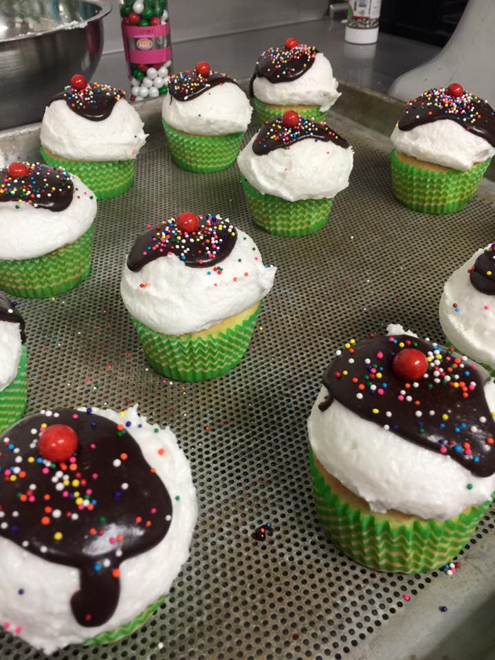 A bunch of cupcakes with chocolate frosting and sprinkles on them