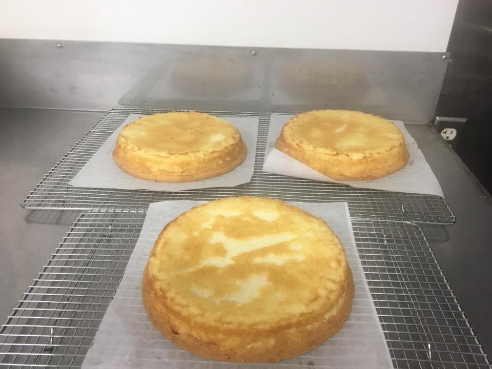 Three cheesecakes are sitting on a cooling rack