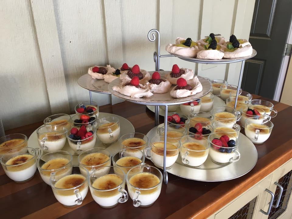 A table topped with plates and cups of desserts.
