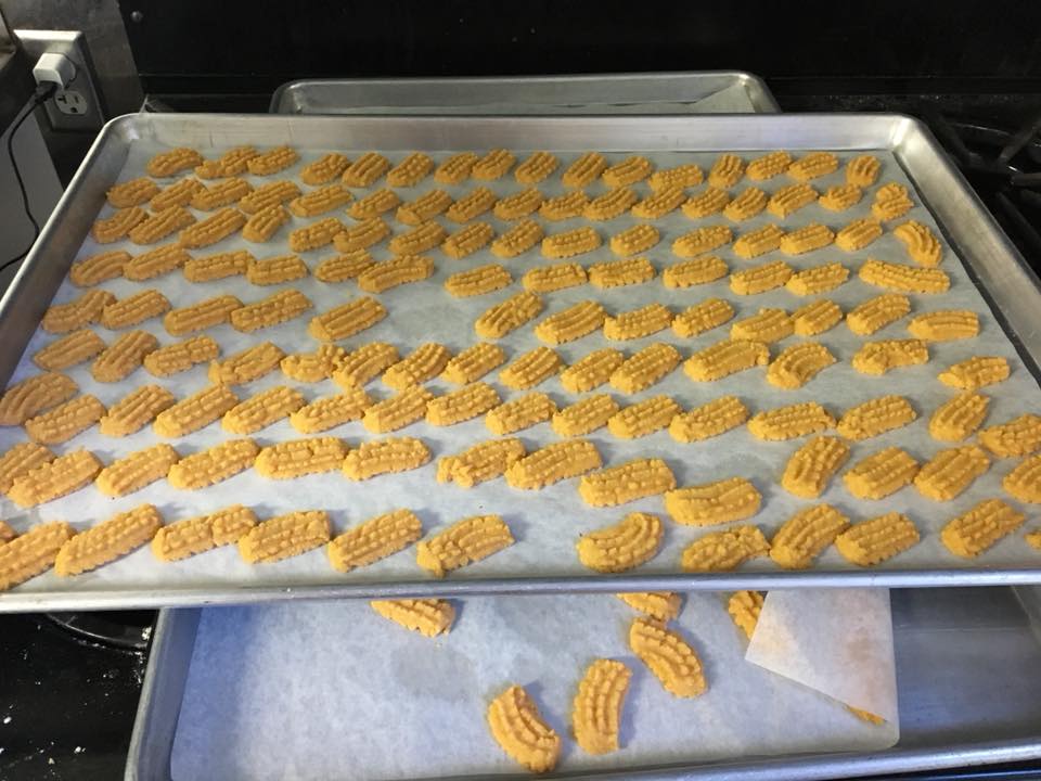 Two trays of cookies are sitting on top of each other on wax paper