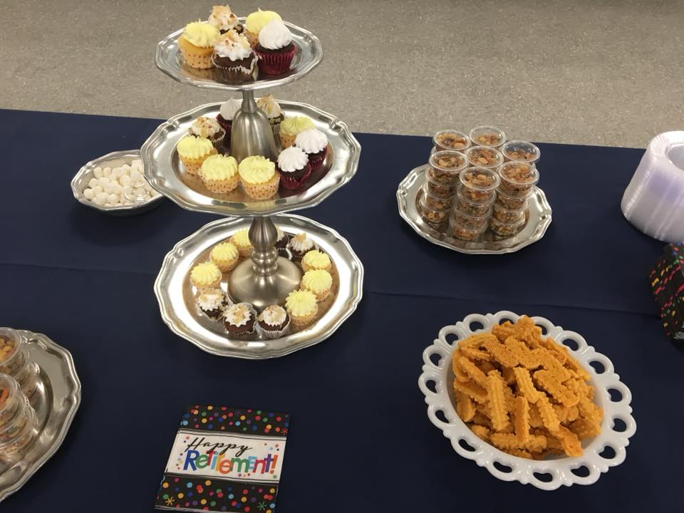 A table with plates of food and a napkin that says happy retirement