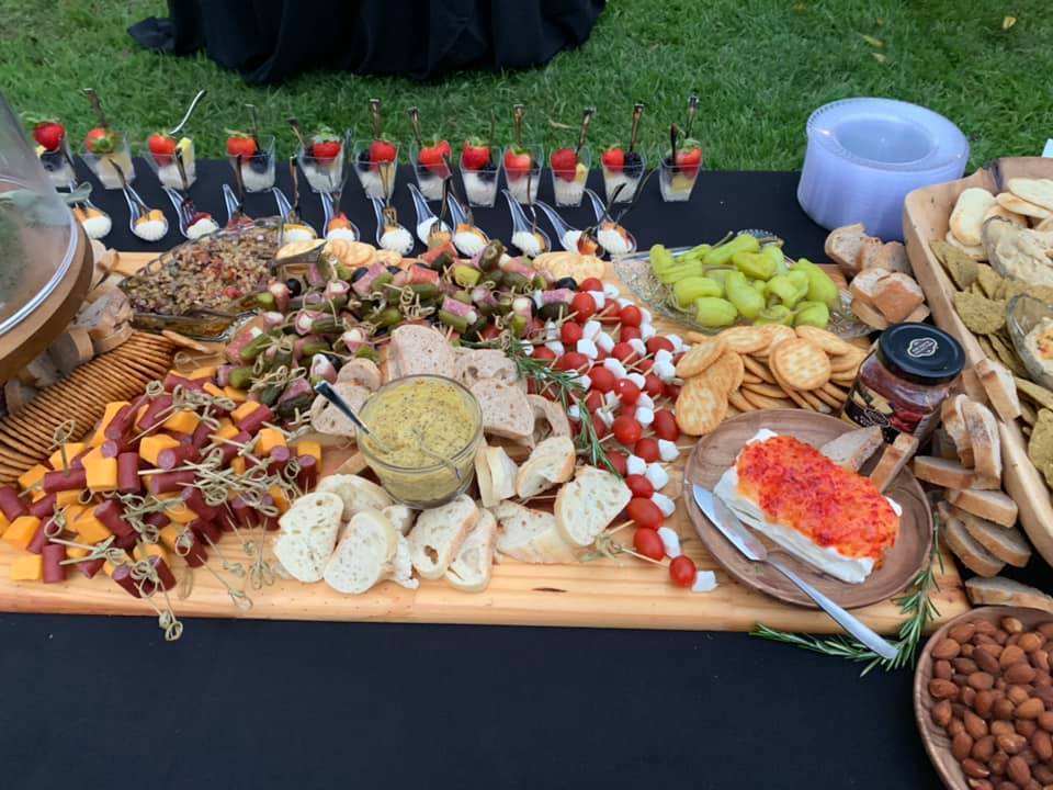 A wooden cutting board filled with lots of different types of food.
