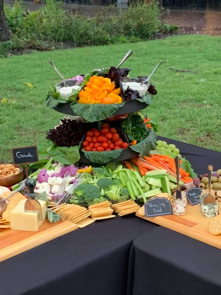 A display of vegetables and cheese on a table outside