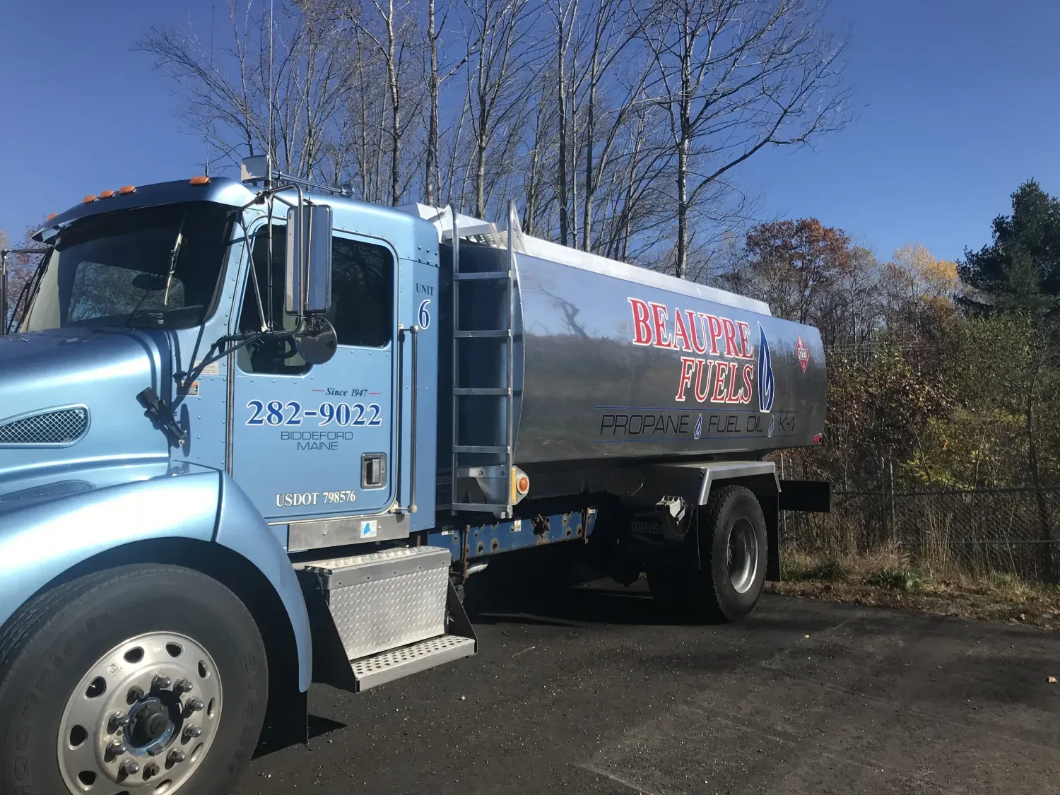 A blue tanker truck is parked on the side of the road.