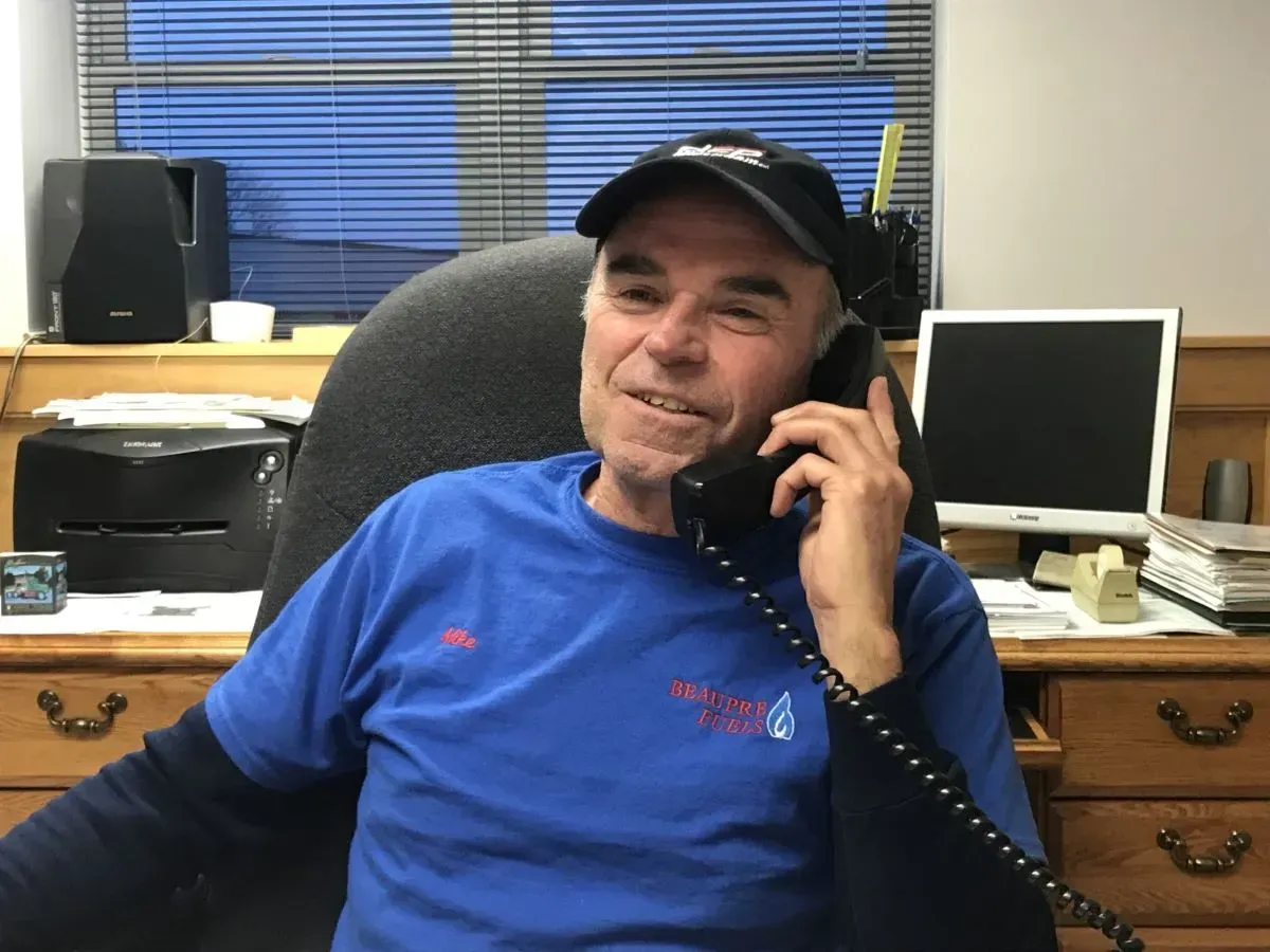 A man in a blue shirt is talking on a phone
