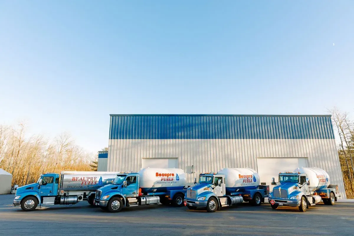 A row of tanker trucks parked in front of a building.
