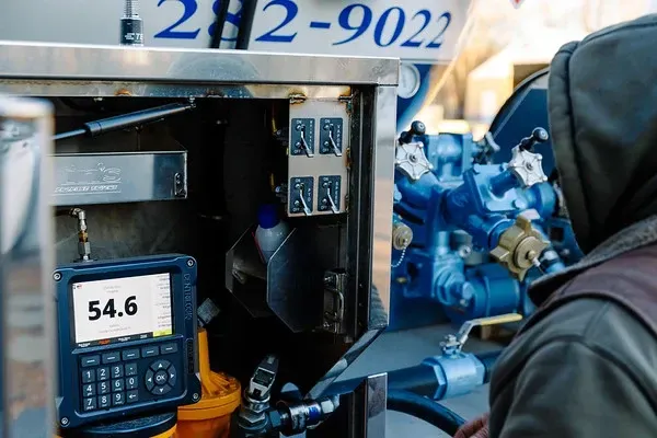 A man is standing in front of a machine that says 54.6 on it
