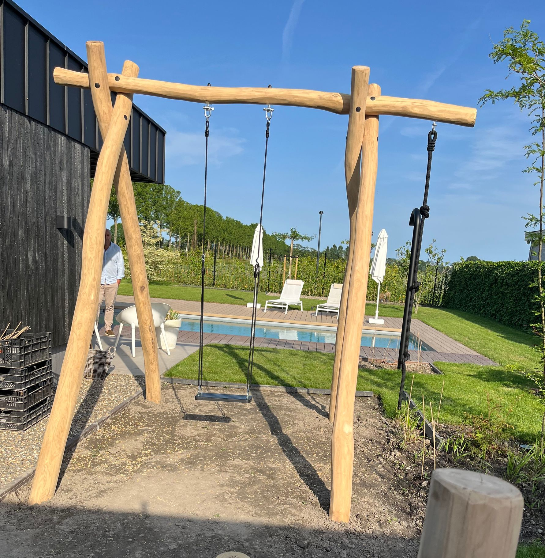 Verticaal gestapelde houten palen, met een natuurlijke lichtbruine kleur, zichtbare houtnerf en lichte imperfecties.