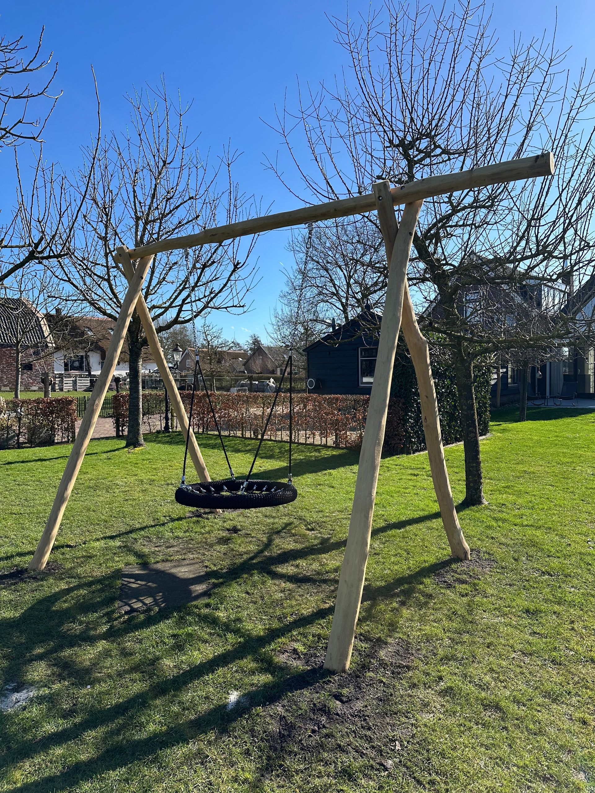 Verticaal gestapelde houten palen, met een natuurlijke lichtbruine kleur, zichtbare houtnerf en lichte imperfecties.