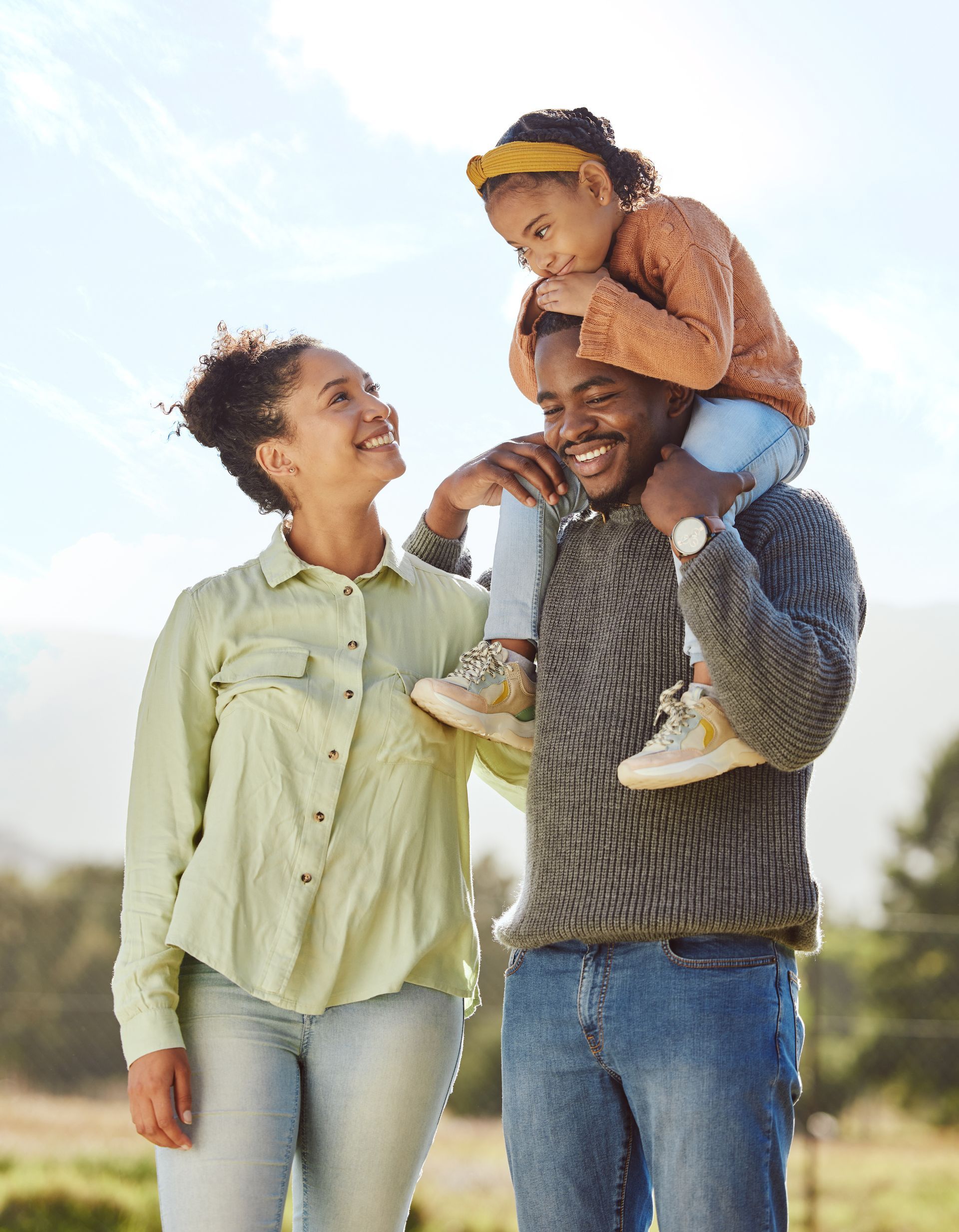 A man is carrying a little girl on his shoulders.