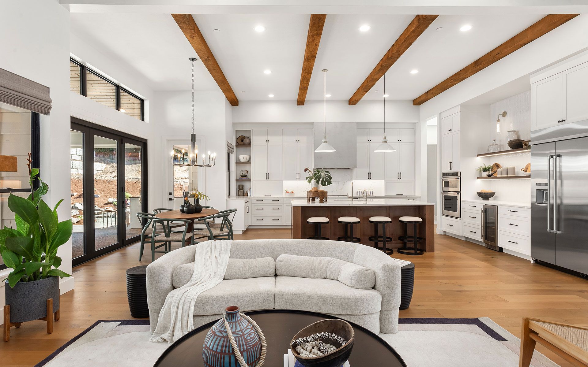 A living room with a couch and a table and a kitchen in the background.