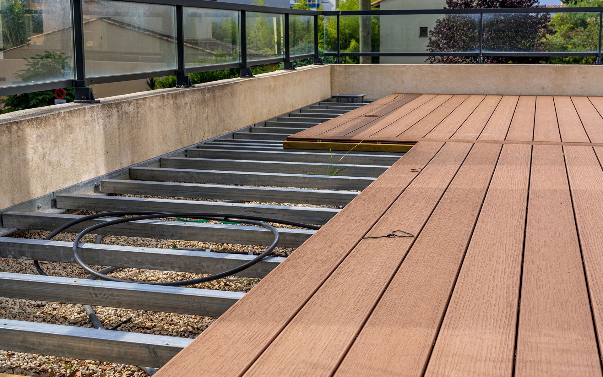 A kitchen with a large island , wooden floors , white cabinets and black stools.