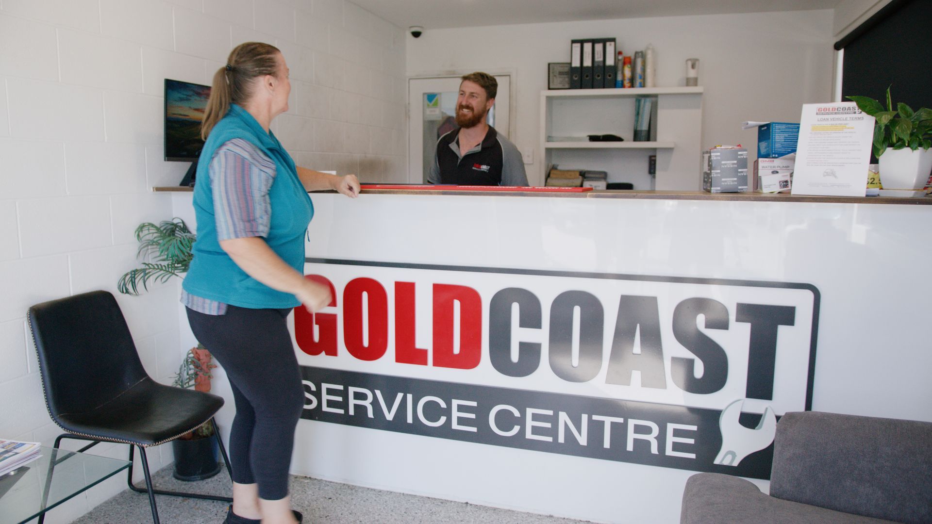 Woman speaking with staff at Gold Coast Service Centre reception desk