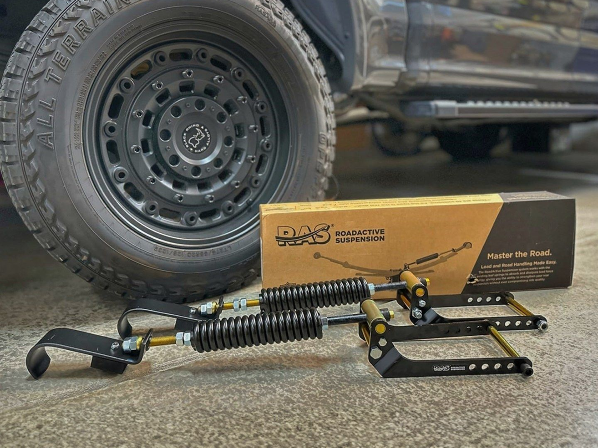 A person writing on a clipboard while inspecting the open engine bay of a car.