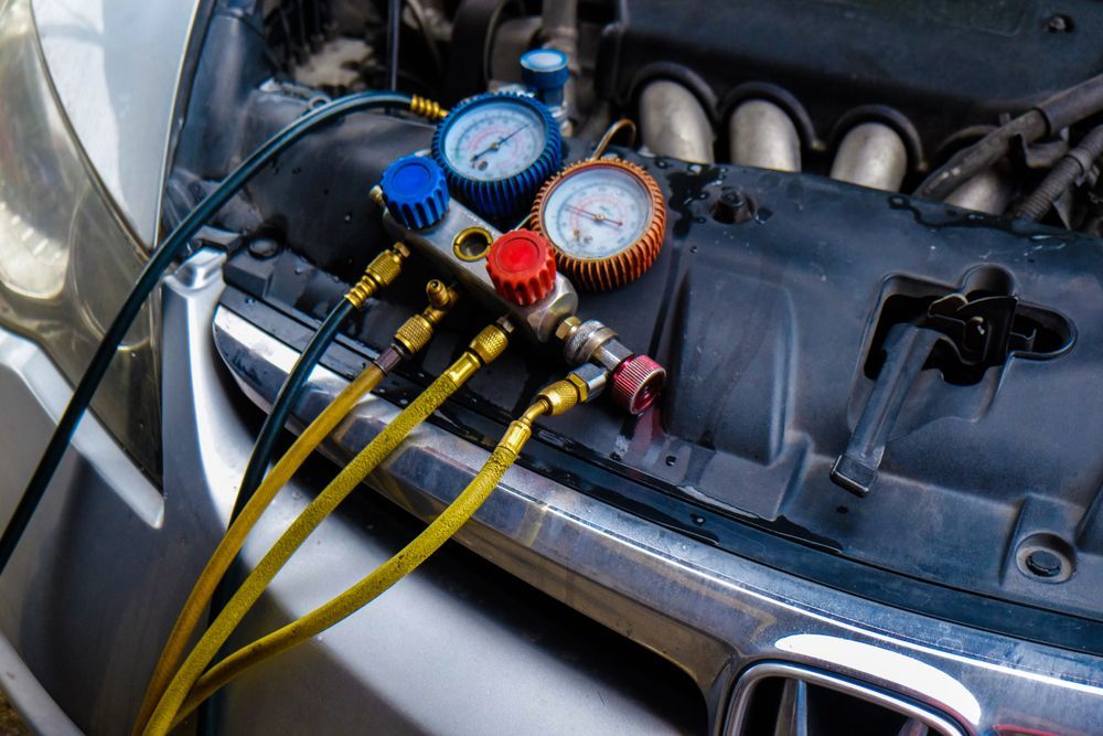 A close-up view of hands using a ratchet wrench to work on a car engine.