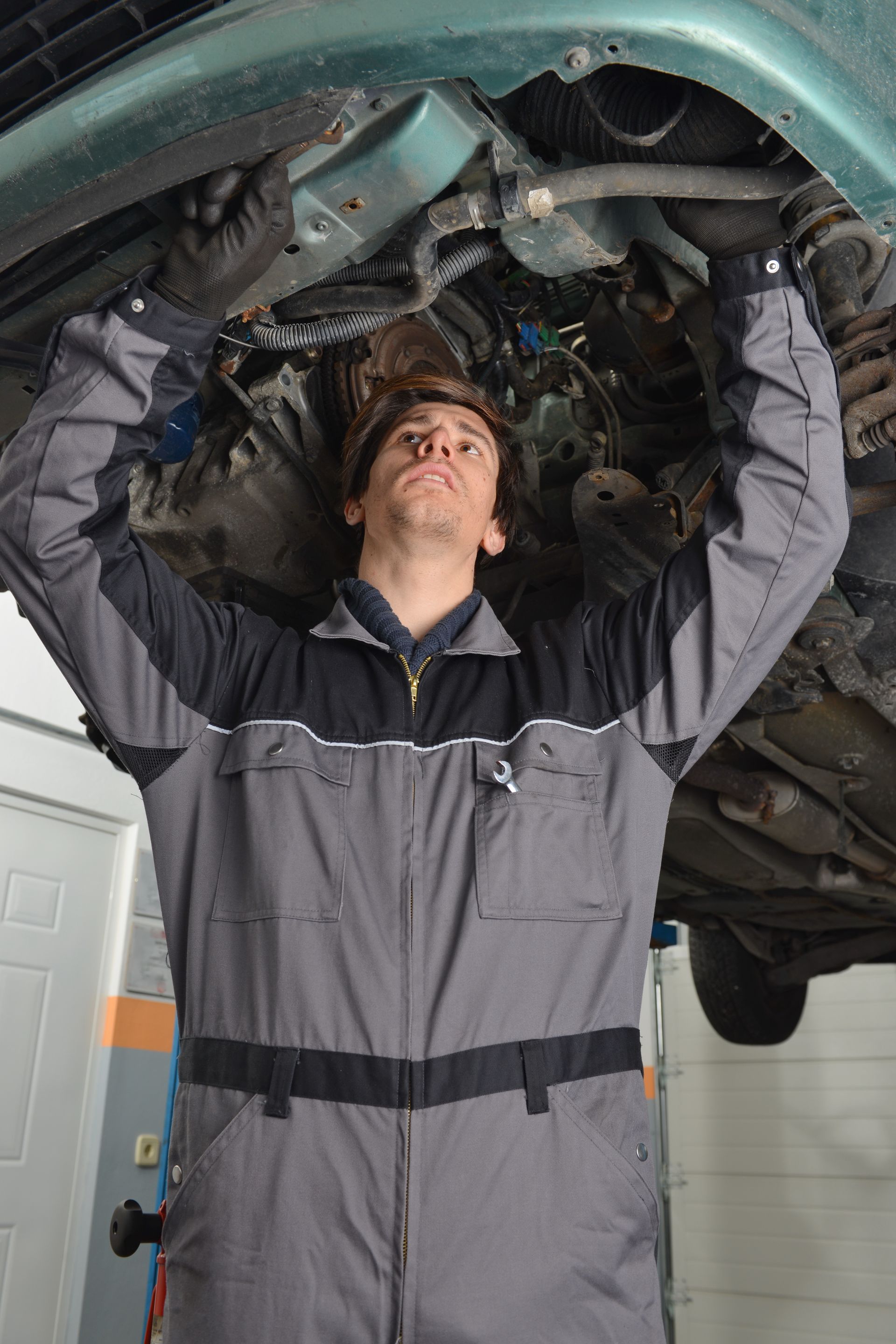A woman hands car keys to another person in a bright, modern car dealership.