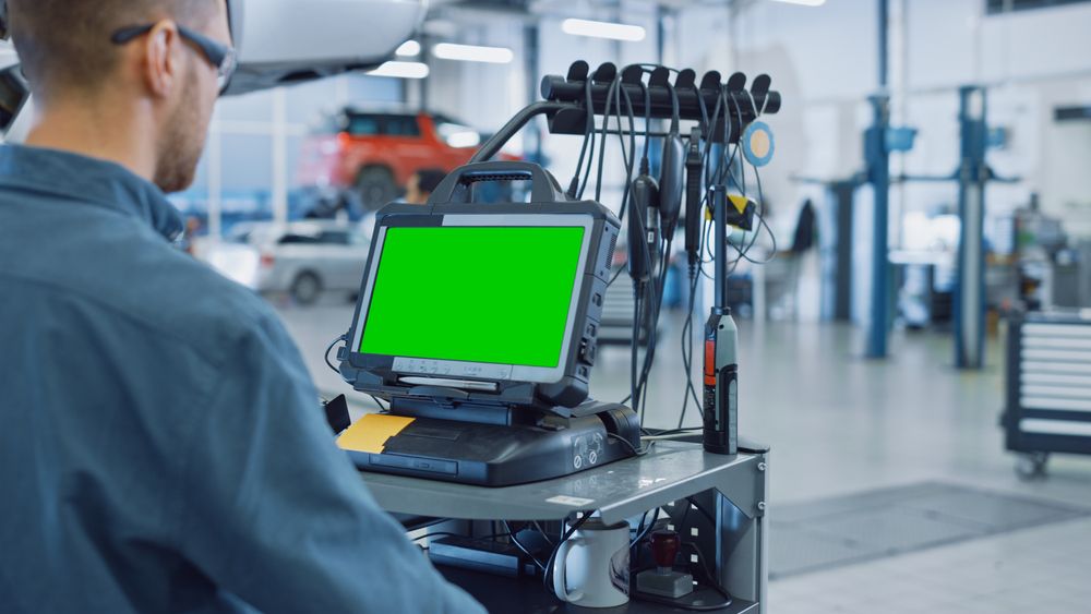 A person writing on a clipboard while inspecting the open engine bay of a car.