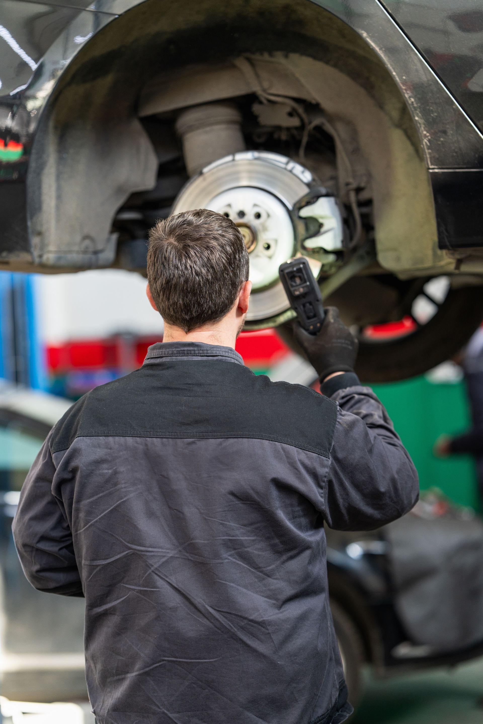 A woman hands car keys to another person in a bright, modern car dealership.