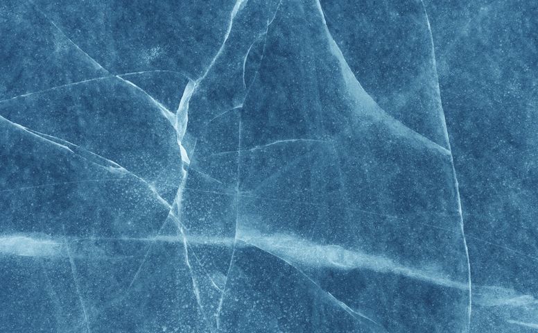 Blue icy surface with white cracks and frosted texture
