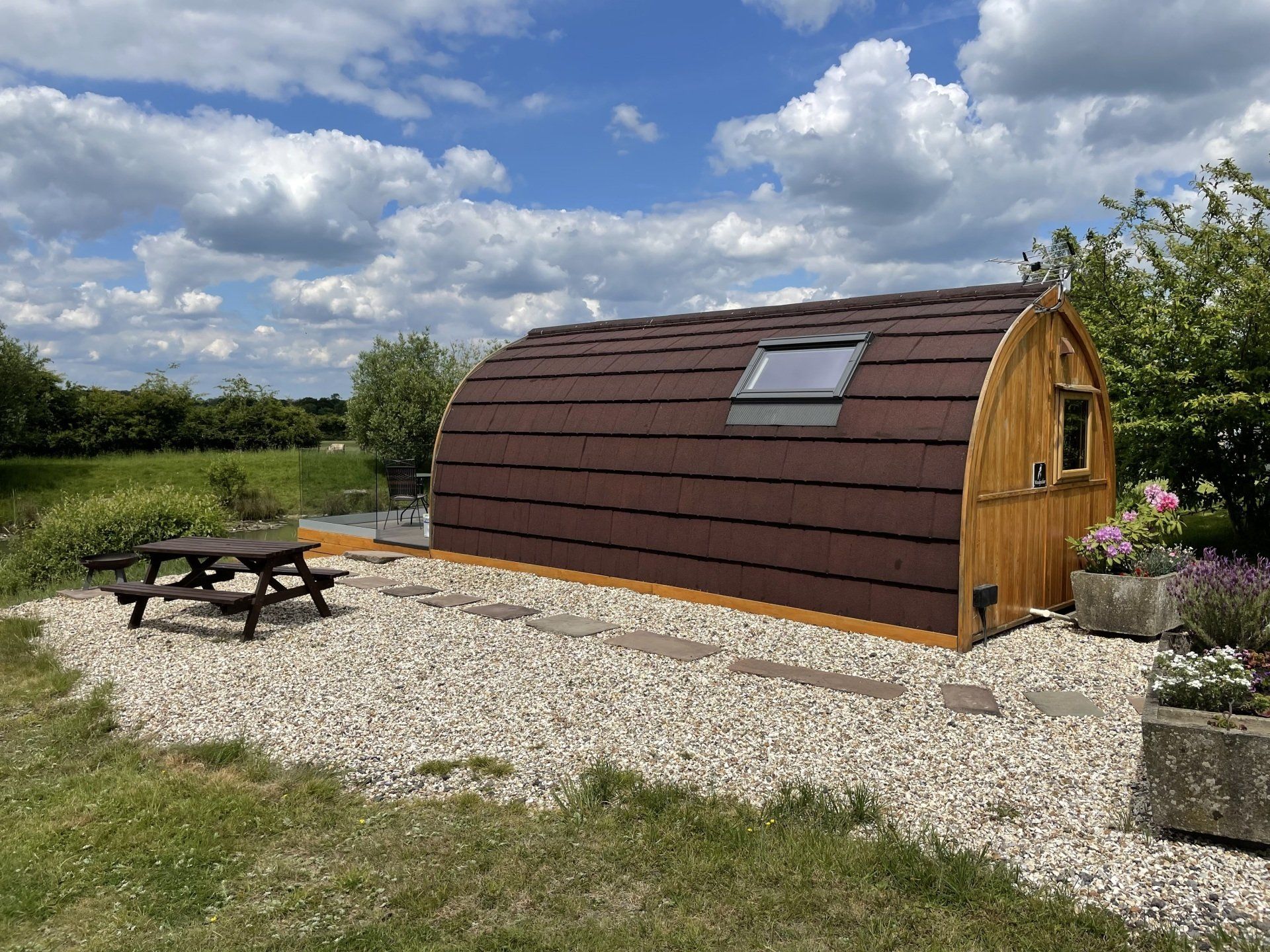 A small wooden hut with a picnic table in front of it.