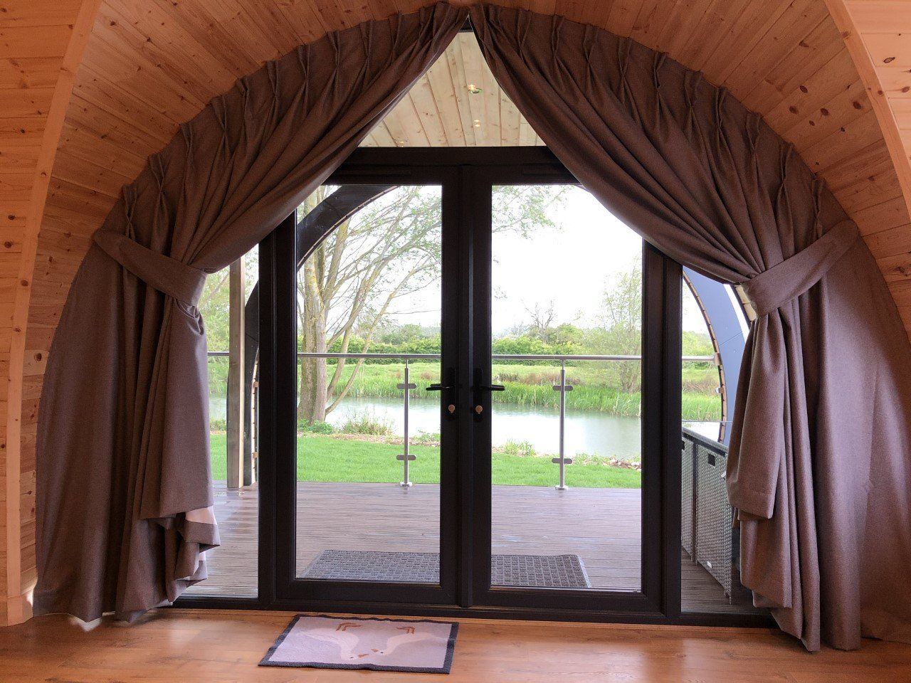 A room with a large window and a view of a lake.