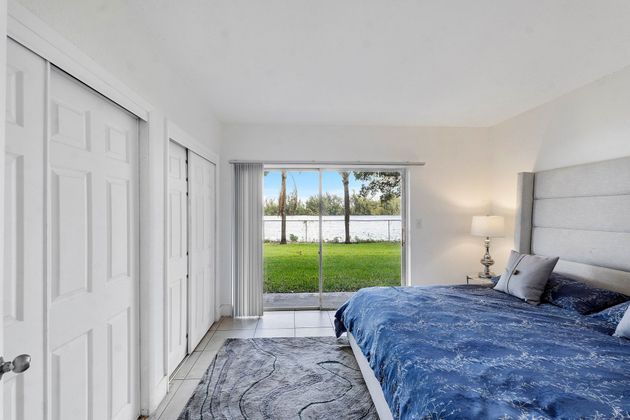 A bedroom with a large bed and a flat screen tv on the wall.