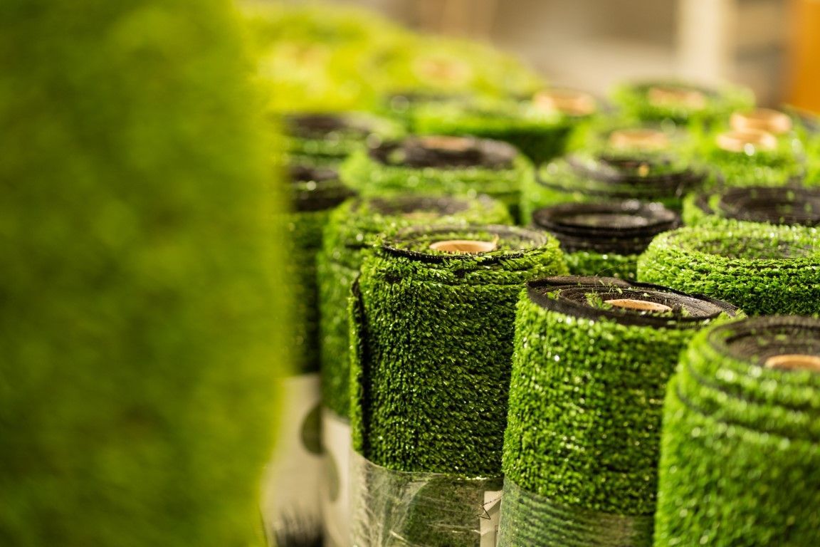 Rolls of artificial green turf stacked together.