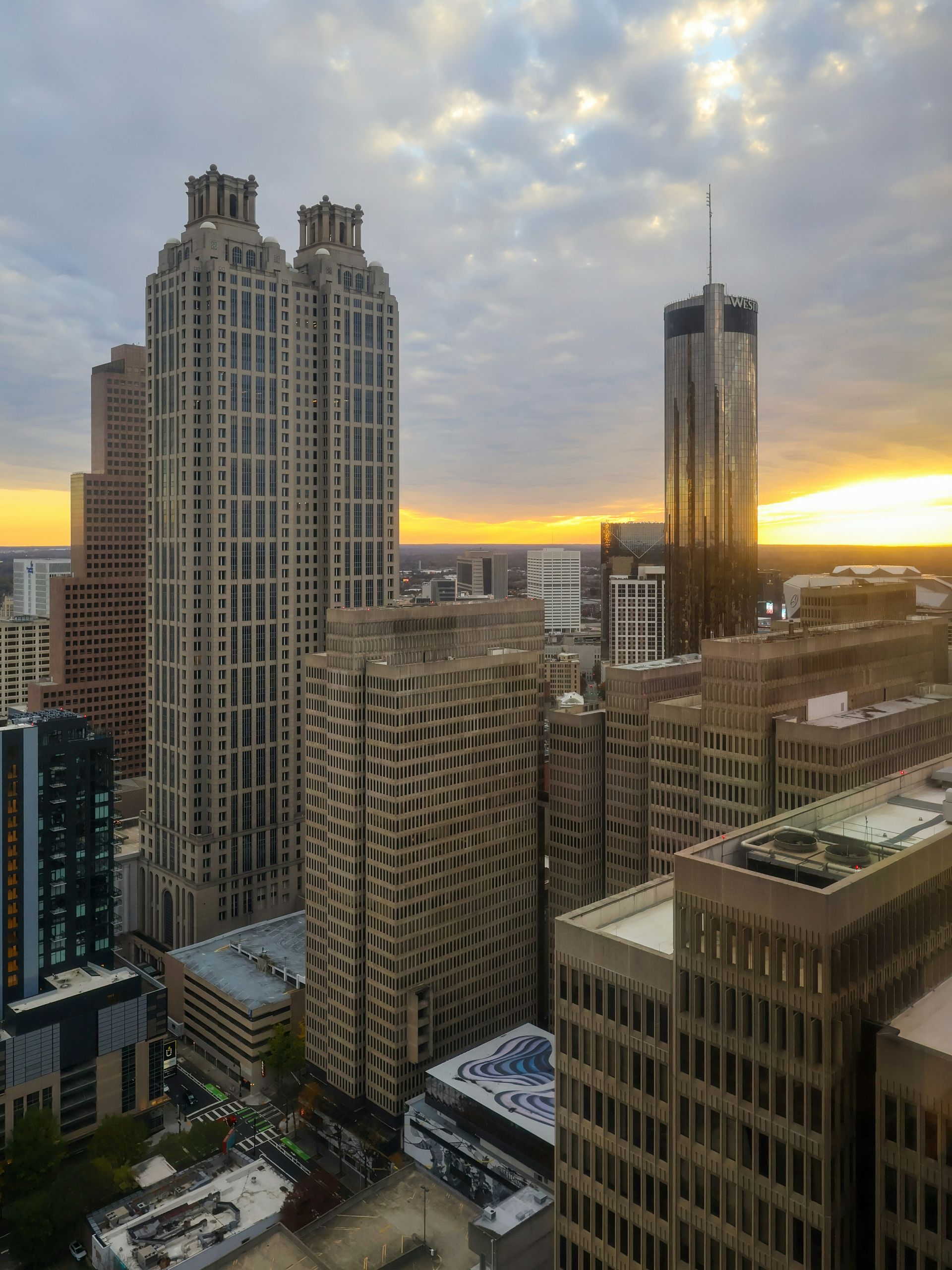 A high-angle view of Atlanta skyscrapers at sunset, with golden light reflecting off the glass towers.