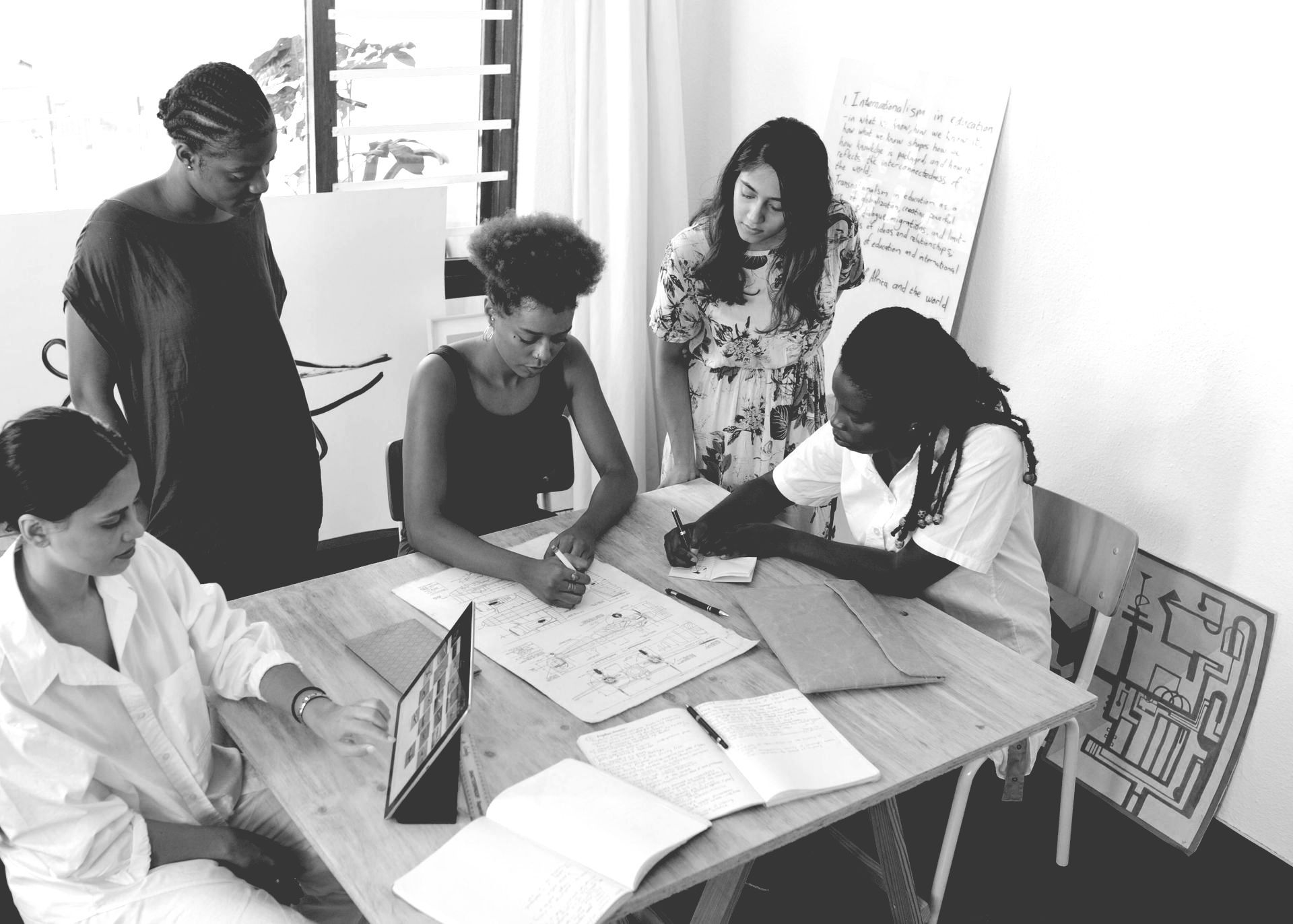 A group of women are sitting around a table working on a project.