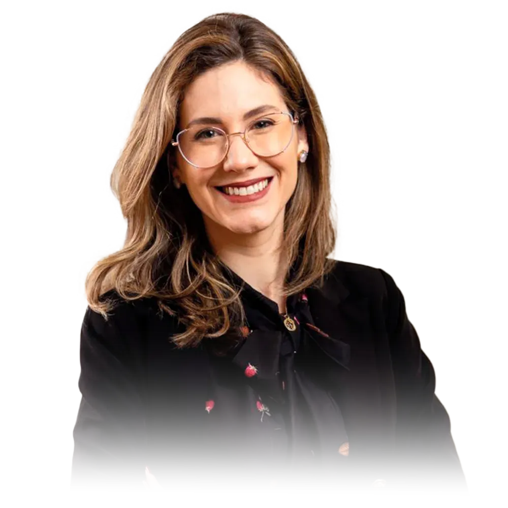 Uma mulher com tranças está sorrindo e vestindo uma camisa vermelha