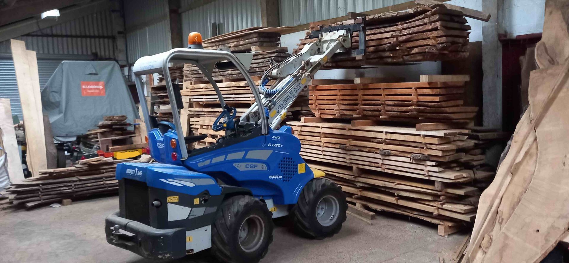 image of our multione loader stacking timber inside the wood barn