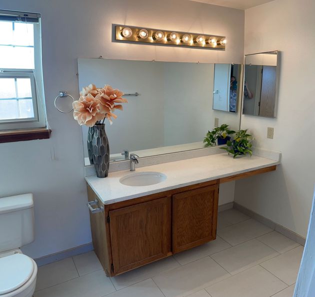 A bathroom with a toilet sink and mirror