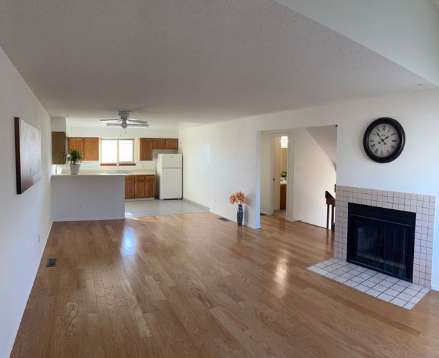 A living room with a fireplace and a clock on the wall