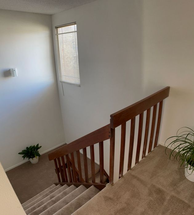 A staircase with a wooden railing and a window