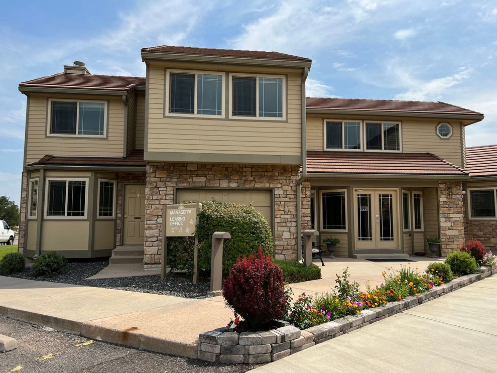 A large house with a lot of windows and flowers in front of it