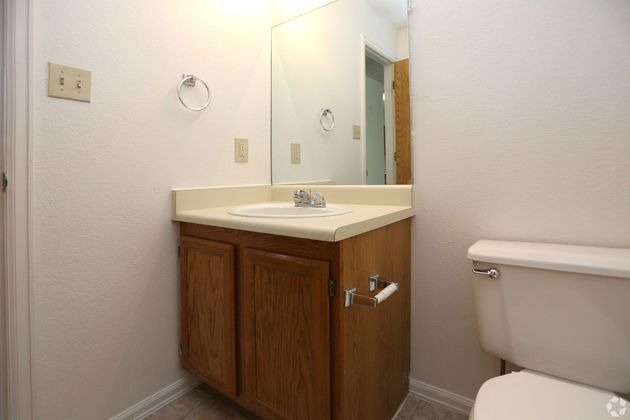 A bathroom with a sink , toilet and mirror.