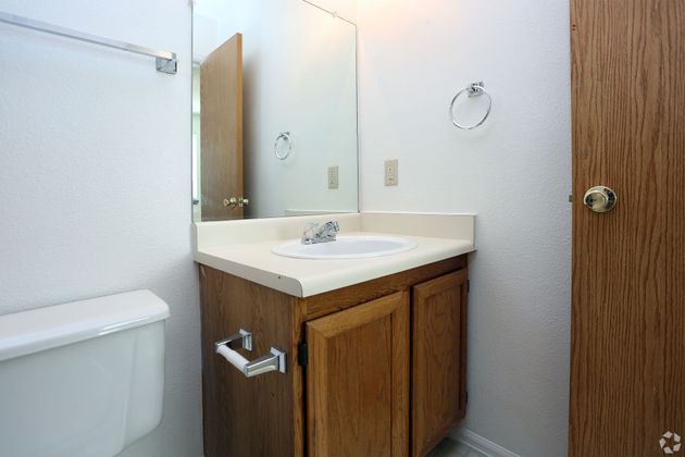 A bathroom with a sink , toilet and mirror.