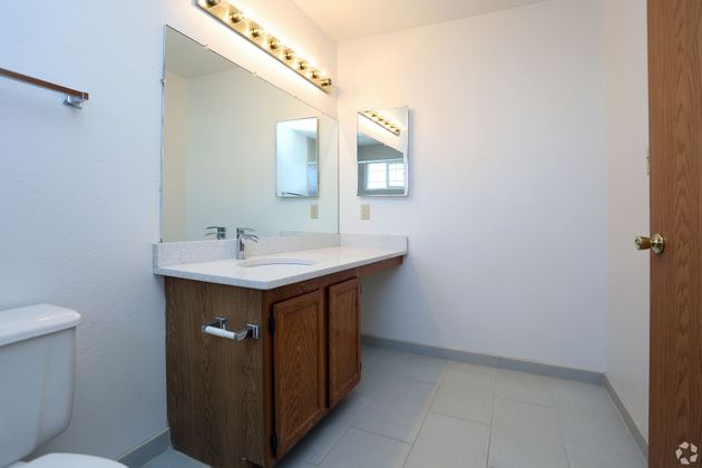 A bathroom with a toilet a sink and a mirror