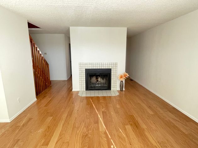 A living room with hardwood floors and a fireplace