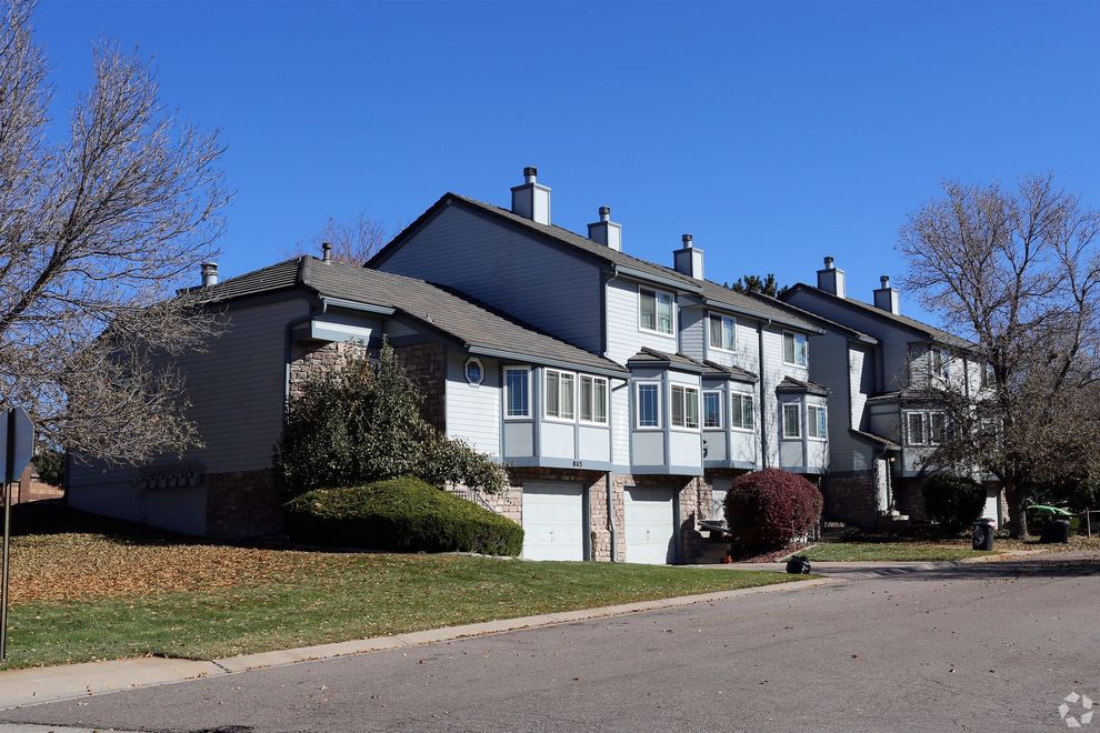 A row of apartment buildings with a blue sky in the background