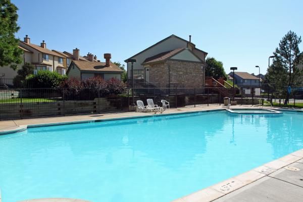 A large swimming pool surrounded by chairs and buildings