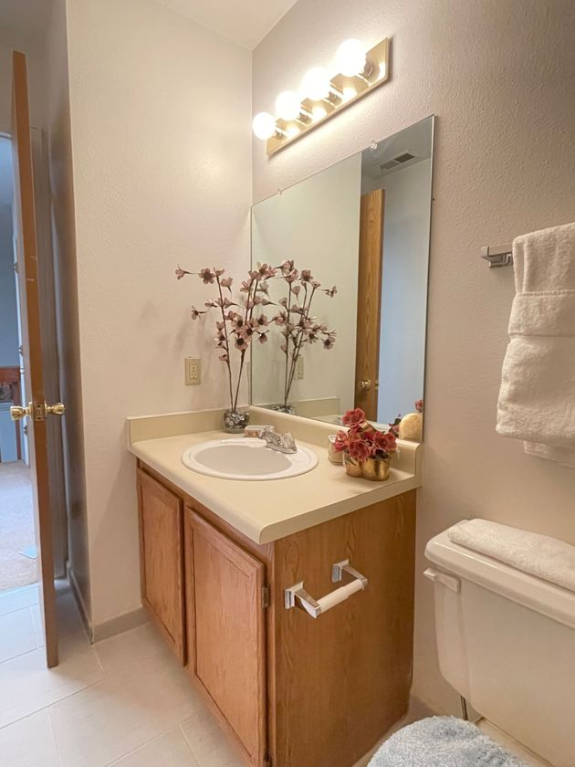 A bathroom with a sink , toilet and mirror.