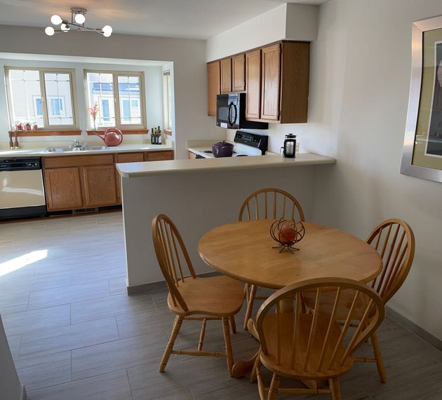 A kitchen with a table and chairs in it