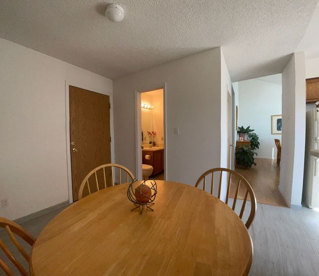 A dining room table with a bowl of fruit on it